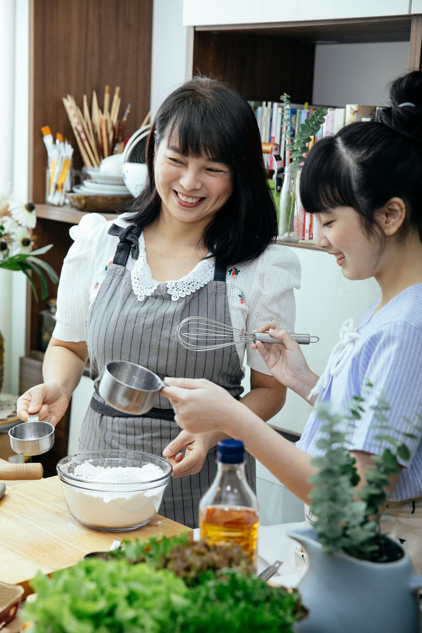 母亲和青春期女儿在家一起做烘焙